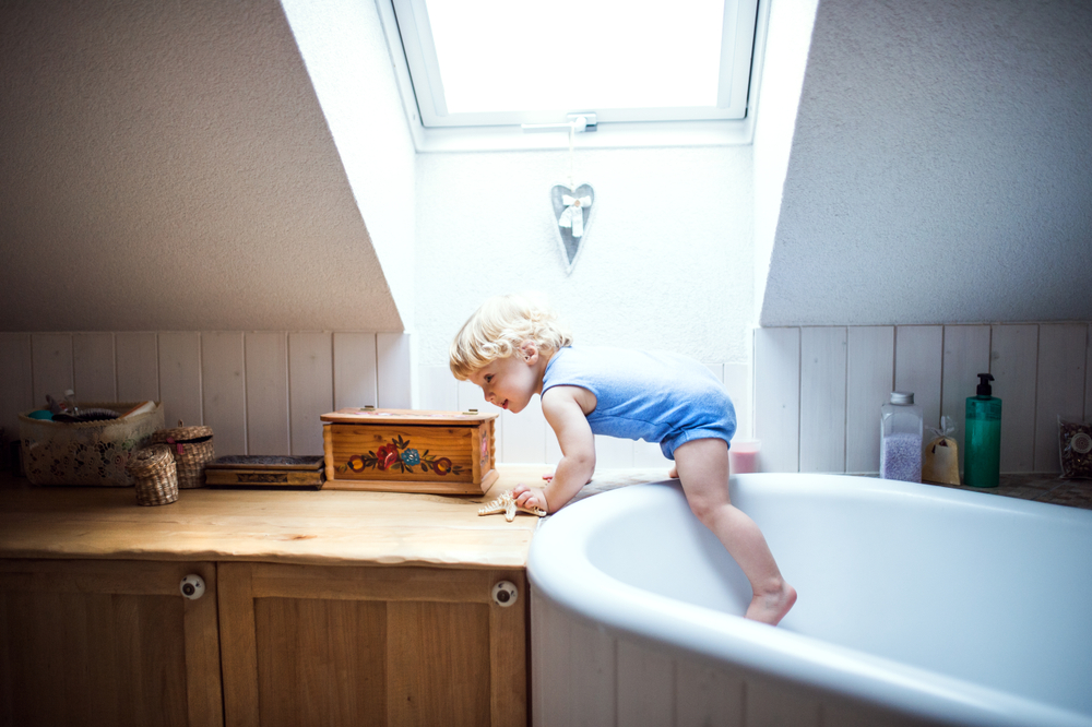 a toddler on a tub filled with water